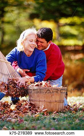 Stock Photo - playful couple and a basket of leaves. Fotosearch