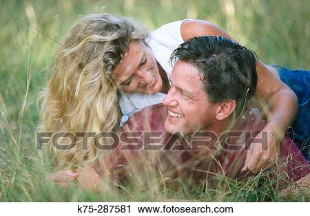 Playful couple in tall grass View Large Photo Image Stock Image - Playful couple in tall grass. Fotosearch