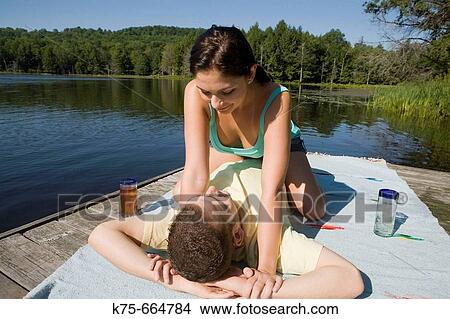 Playful couple on dock enjoying the sun View Large Photo Image Picture - Playful couple on dock enjoying the sun. Fotosearch