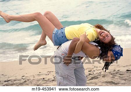 playful couple on the beach View Large Photo Image Stock Image - playful couple on the beach. Fotosearch