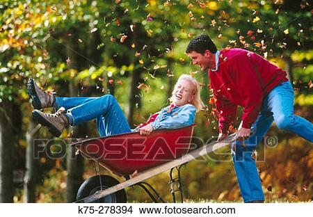 Picture - Playful couple with wheelbarrow. Fotosearch