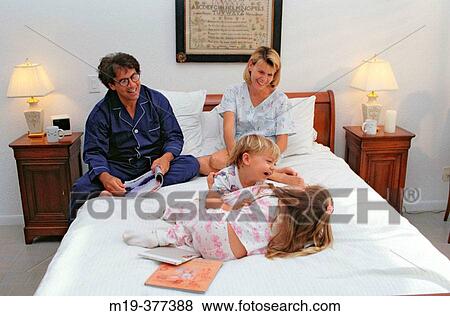 playful family on a bed View Large Photo Image Stock Photo - playful family on a bed. Fotosearch