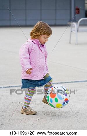 Playful female toddler with a ball View Large Photo Image Stock Image - Playful female toddler with a ball. Fotosearch