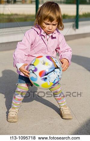 Stock Photo - Playful female toddler with a ball. Fotosearch