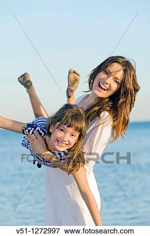 Playful mother and daughter at the beach View Large Photo Image Stock Photo - Playful mother and daughter at the beach. Fotosearch