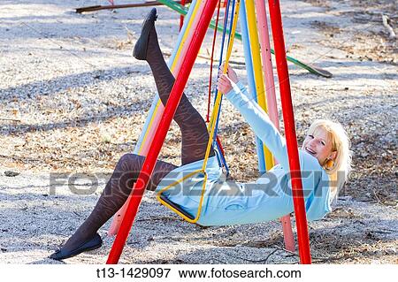 Playful on a swing young woman in short Blue dress View Large Photo Image Stock Photo - Playful on a swing young woman in short Blue dress. Fotosearch