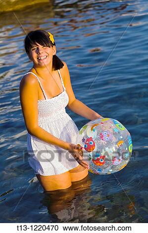 Stock Image - Playful teenager girl with a ball. Fotosearch