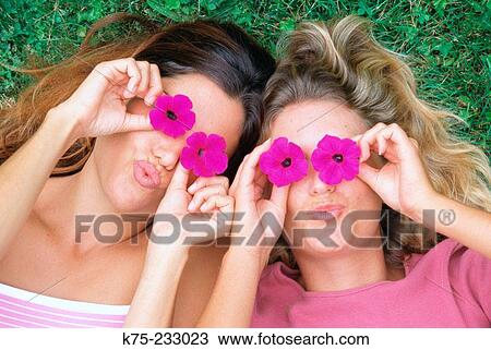 Stock Image - Playful women with flowers. Fotosearch