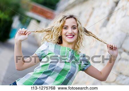 Stock Photo - Playful young woman is pulling her hair apart. Fotosearch