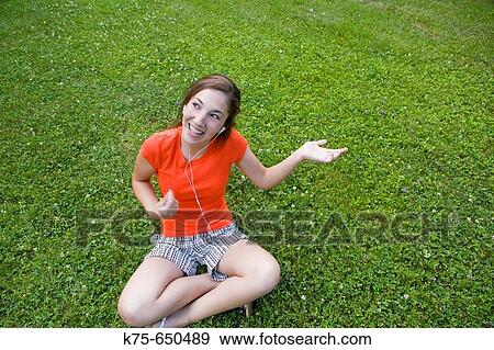Stock Photo - Playing air guitar and listening to mp 3 player. Fotosearch
