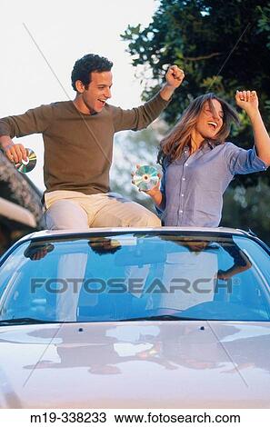 Stock Image - playing CDs in a car and dancing. Fotosearch