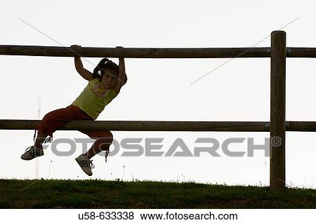 Playing in a fence. View Large Photo Image Stock Photo - Playing in a fence.. Fotosearch