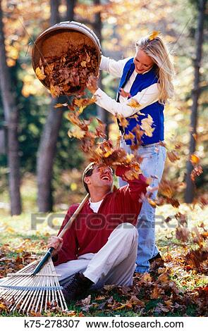 Stock Photo - Playing in a leaf pile. Fotosearch