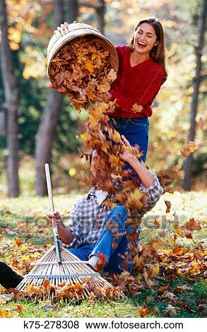 Playing with a pile of leaves View Large Photo Image Stock Photo - Playing with a pile of leaves. Fotosearch