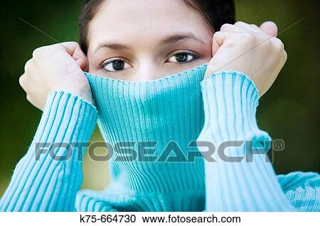 Stock Image - Playing with her turtleneck. Fotosearch