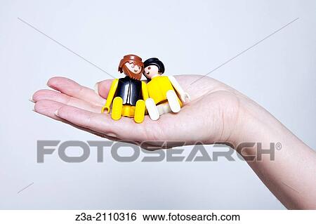 Stock Photograph - Playmobil Couple In Love, Sitting In Handpalm, Hand Gesture, Studio shot. Fotosearch