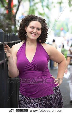 Plus size caucasian woman smiling and looking into camera View Large Photo Image Stock Photograph - Plus size caucasian woman smiling and looking into camera. Fotosearch