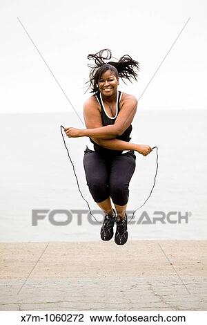 Plus size model jumping rope at a marina park View Large Photo Image Stock Image - Plus size model jumping rope at a marina park. Fotosearch