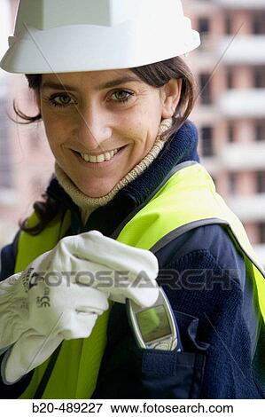 Stock Photo - Pocket for mobile phone. Technician with safety equipment. Housing construction, apartments. San Sebastian, Gipuzkoa, Euskadi. Spain.. Fotosearch