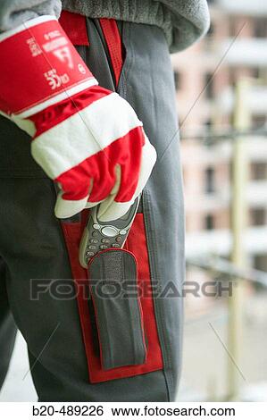 Pocket for mobile phone. Technician with safety equipment. Housing construction, apartments. San Sebastian, Gipuzkoa, Euskadi. Spain. View Large Photo Image Stock Photograph - Pocket for mobile phone. Technician with safety equipment. Housing construction, apartments. San Sebastian, Gipuzkoa, Euskadi. Spain.. Fotosearch