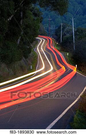Stock Image - Point Reyes-Petaluma Road, Marin County, California, USA, with car headlight and tail light streaks at dusk. Fotosearch