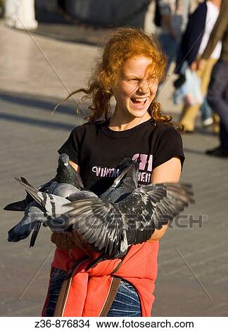 Poland, Krakow, Main Market Square, pigeons and girl having fun View Large Photo Image Picture - Poland, Krakow, Main Market Square, pigeons and girl having fun. Fotosearch