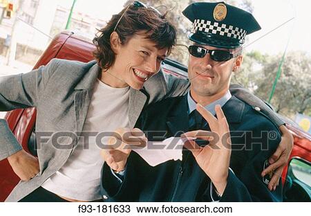 Stock Image - Policeman tearing up a traffic ticket. Fotosearch
