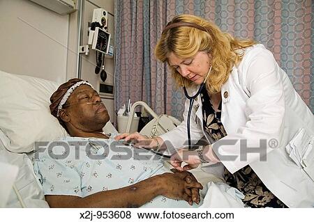 Pontiac, Michigan - Peg Nelson, a nurse practitioner at St Joseph Mercy Oakland Hospital, checks the vital signs of a patient, Miyoshi Scott Nelson runs a pain- and palliative-care program for those at the end of life View Large Photo Image Stock Photo - Pontiac, Michigan - Peg Nelson, a nurse practitioner at St Joseph Mercy Oakland Hospital, checks the vital signs of a patient, Miyoshi Scott Nelson runs a pain- and palliative-care program for those at the end of life. Fotosearch