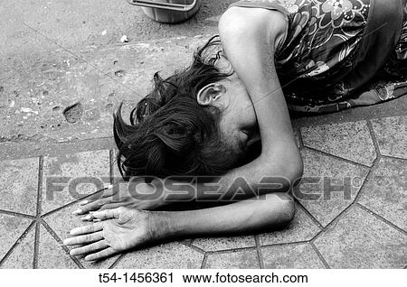 Stock Image - Poor Beggar sleeping on the Street. Fotosearch