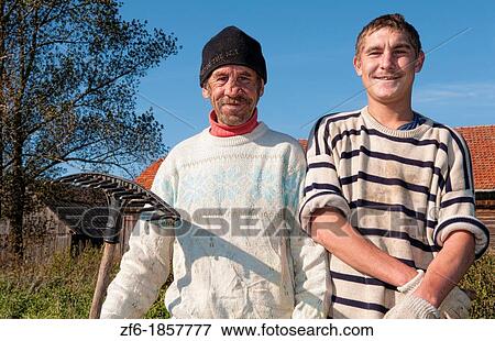 Stock Photo - Poor simple father son farmers working in farm in Marijampole in country near Vilnius Lithuania. Fotosearch