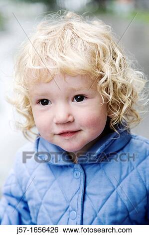 Porrtait of a young girl in a blue jacket with curly blond hair View Large Photo Image Stock Photograph - Porrtait of a young girl in a blue jacket with curly blond hair. Fotosearch