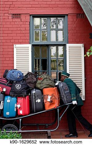 Porter in green uniform moving a cart loaded with luggage at Rovos Rail station, Pretoria, South Africa View Large Photo Image Stock Image - Porter in green uniform moving a cart loaded with luggage at Rovos Rail station, Pretoria, South Africa. Fotosearch