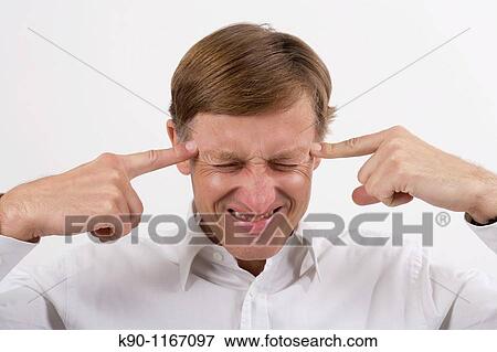 Stock Photo - Portrait - head and shoulders - of caucasian man pointing with his fingers to his head, studio shot. Fotosearch