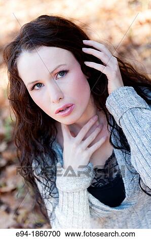 Stock Image - Portrait of 24 year old brunette woman in a back yard in the fall. Fotosearch