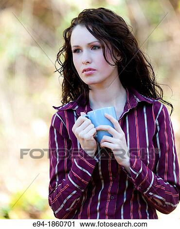 Portrait of 24 year old brunette woman holding a coffee cup in a back yard in the fall View Large Photo Image Stock Image - Portrait of 24 year old brunette woman holding a coffee cup in a back yard in the fall. Fotosearch
