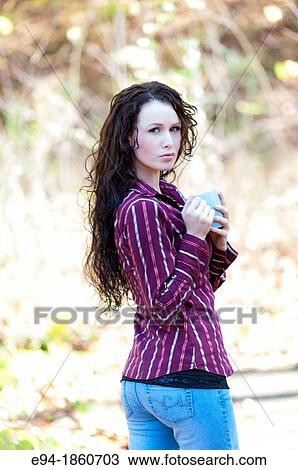 Portrait of 24 year old brunette woman holding a coffee cup in a back yard in the fall View Large Photo Image Stock Image - Portrait of 24 year old brunette woman holding a coffee cup in a back yard in the fall. Fotosearch