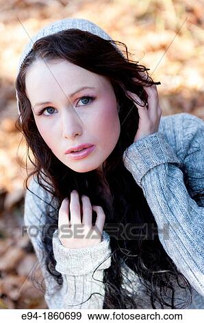 Stock Photo - Portrait of 24 year old brunette woman in a back yard in the fall. Fotosearch