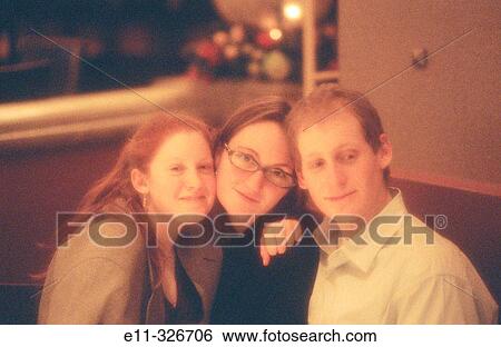 Stock Photograph - Portrait of 3 young people in restaurant. Fotosearch