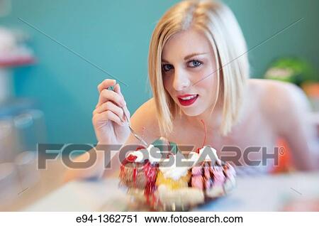Portrait of a 19 year old blond woman looking directly at camera with a big dessert in front View Large Photo Image Stock Image - Portrait of a 19 year old blond woman looking directly at camera with a big dessert in front. Fotosearch