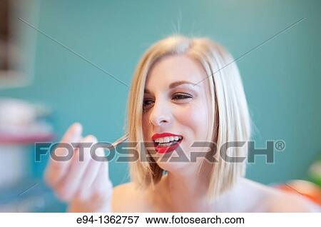Portrait of a 19 year old blond woman making a funny face and holing a spoon in one hand. View Large Photo Image Stock Photo - Portrait of a 19 year old blond woman making a funny face and holing a spoon in one hand.. Fotosearch