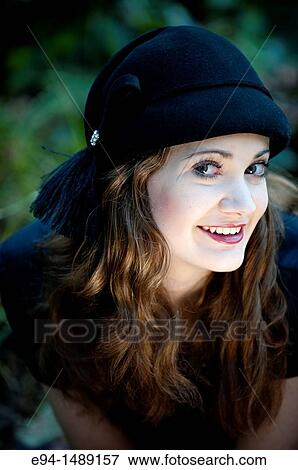Portrait of a 19 year old brunette woman wearing a hat in a garden setting. View Large Photo Image Stock Photo - Portrait of a 19 year old brunette woman wearing a hat in a garden setting.. Fotosearch