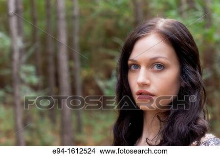 Portrait of a 20 year old brunettte woman looking directly at the camera outdoors View Large Photo Image Picture - Portrait of a 20 year old brunettte woman looking directly at the camera outdoors. Fotosearch