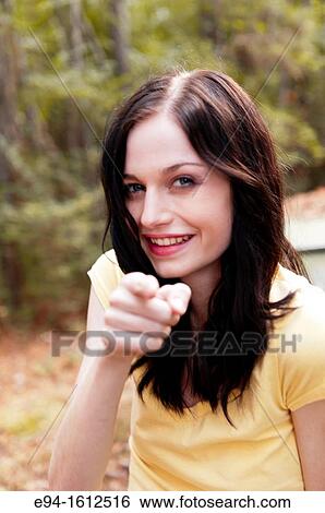 Portrait of a 20 year old brunettte woman laughing and pointing her finger at the camera View Large Photo Image Stock Photograph - Portrait of a 20 year old brunettte woman laughing and pointing her finger at the camera. Fotosearch
