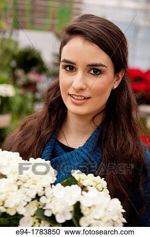 Portrait of a 21 year old brunette woman shoopping in a plant nursery View Large Photo Image Stock Image - Portrait of a 21 year old brunette woman shoopping in a plant nursery. Fotosearch