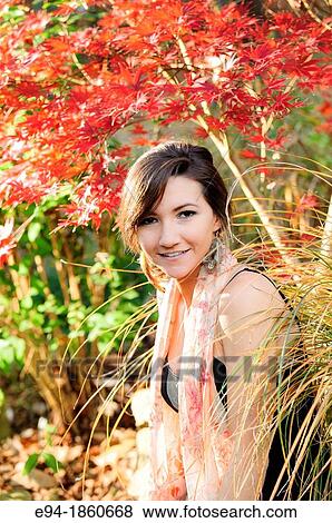 Portrait of a 21 year old woman in a garden setting in the fall View Large Photo Image Stock Photo - Portrait of a 21 year old woman in a garden setting in the fall. Fotosearch