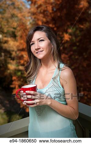 Portrait of a 21 year old woman outdoors holding a cup of tea View Large Photo Image Stock Image - Portrait of a 21 year old woman outdoors holding a cup of tea. Fotosearch