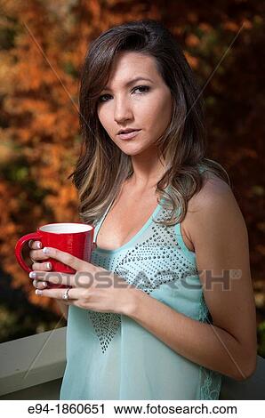 Portrait of a 21 year old woman outdoors holding a cup of tea View Large Photo Image Stock Image - Portrait of a 21 year old woman outdoors holding a cup of tea. Fotosearch