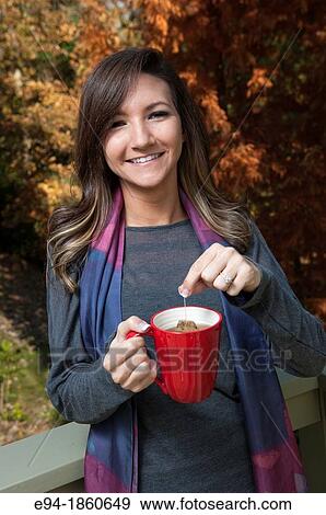 Portrait of a 21 year old woman outdoors holding a cup of tea View Large Photo Image Stock Photo - Portrait of a 21 year old woman outdoors holding a cup of tea. Fotosearch