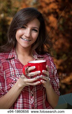 Portrait of a 21 year old woman outdoors holding a cup of tea View Large Photo Image Stock Photograph - Portrait of a 21 year old woman outdoors holding a cup of tea. Fotosearch