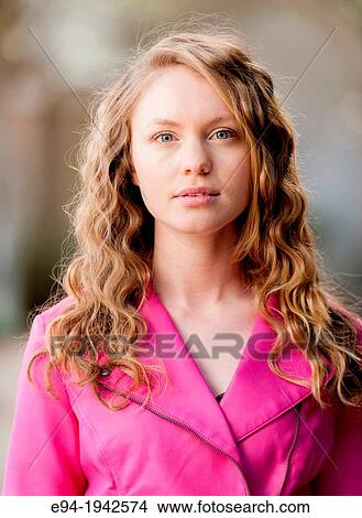 Picture - Portrait of a 22 year old blond woman outdoors wearing a pink jacket.. Fotosearch